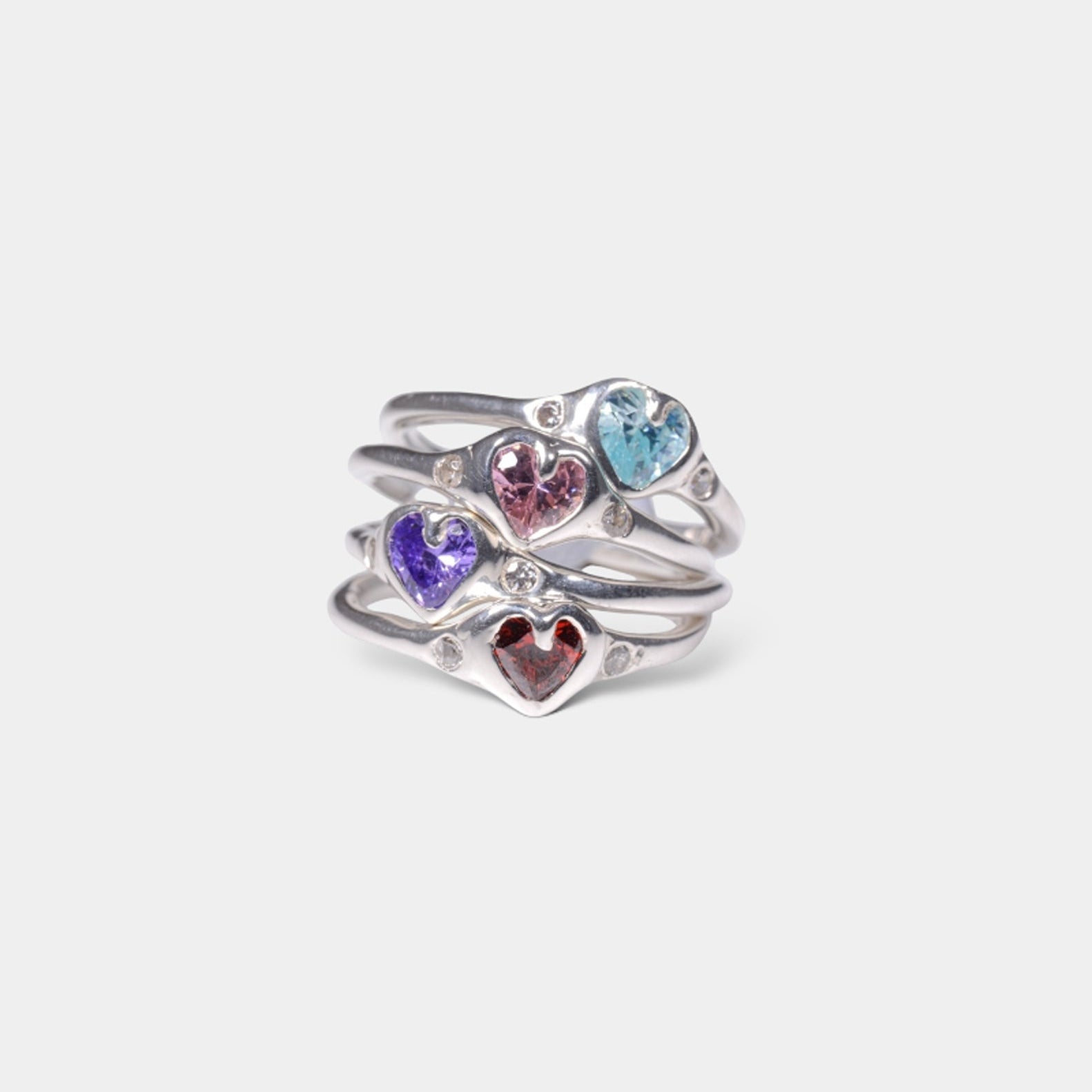 A heart-shaped ring with multiple colored gemstones, displayed against a white background.