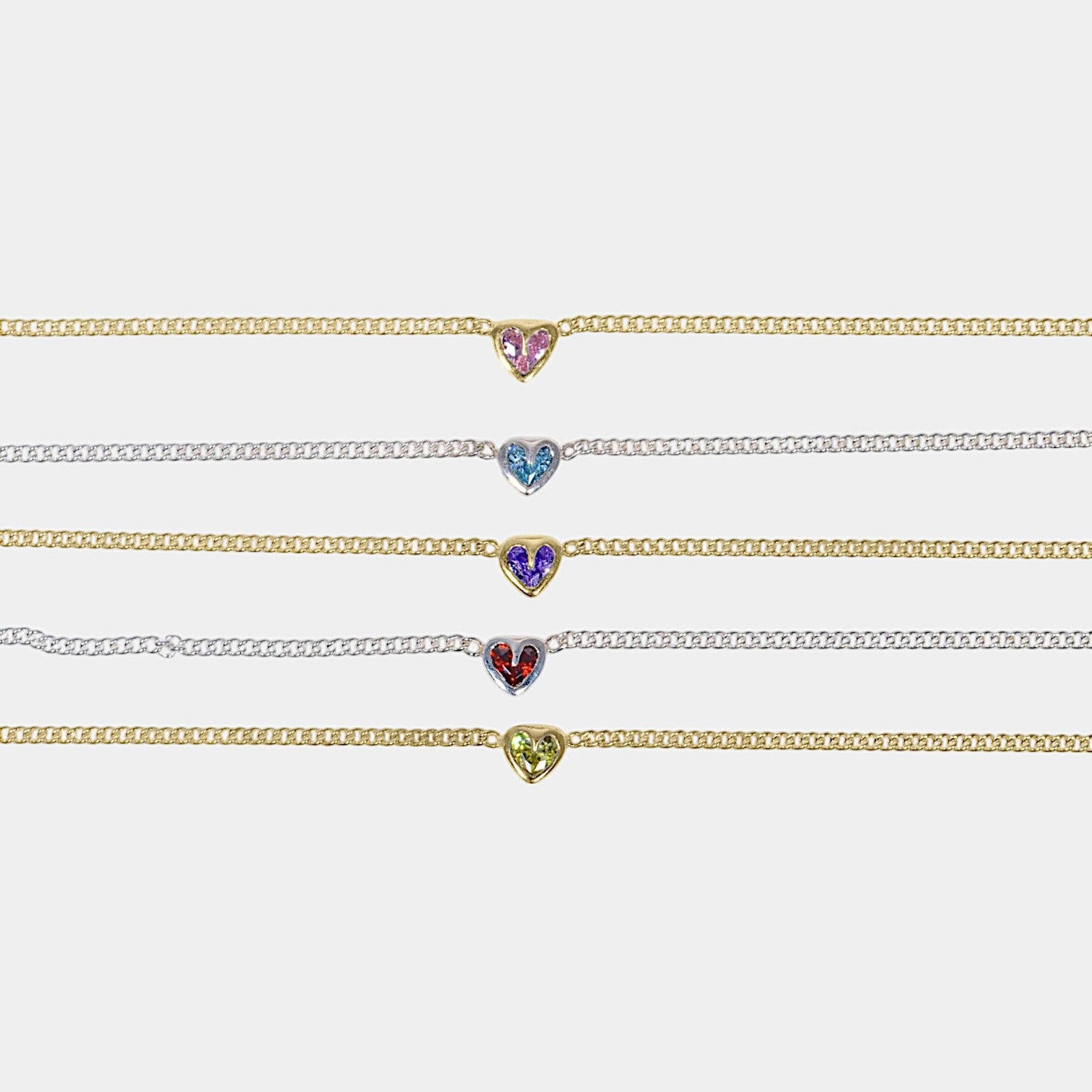 A collection of heart-shaped necklaces with various colored gemstones set in gold and silver chains, displayed against a white background.